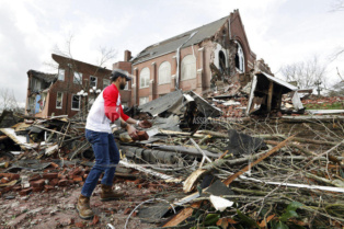 Sumant Joshi helps to clean up rubble at the East End United Methodist Church after it was heavily damaged by storms Tuesday, March 3, 2020, in Nashville, Tenn. Joshi is a resident in the area and volunteered to help clean up. Tornadoes ripped across Tennessee early Tuesday, shredding buildings and killing multiple people.  (AP Photo/Mark Humphrey)