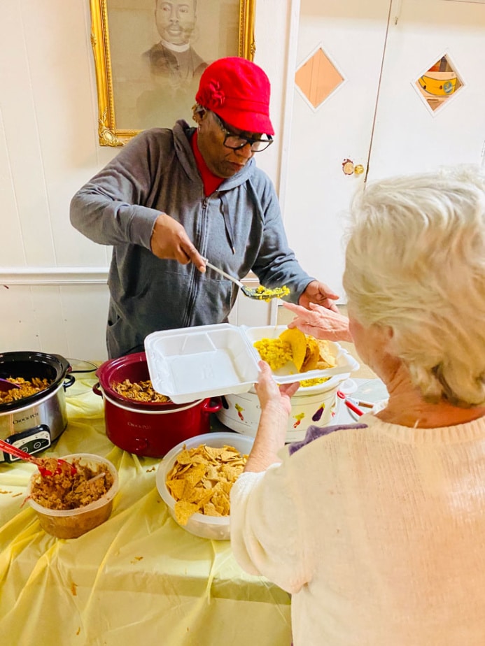 Gwenda Motley dishing out food at Aaron McNeil House