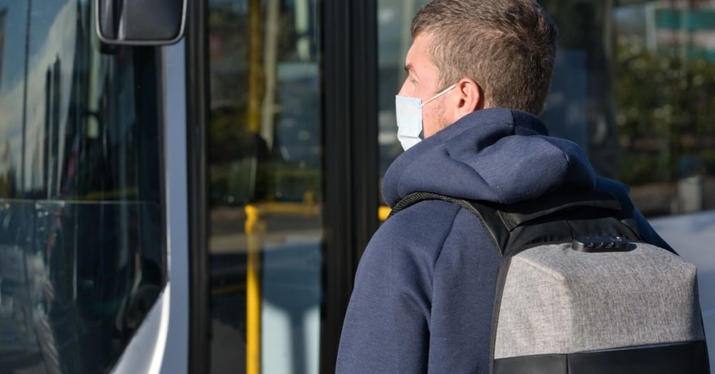 man on public transportation wearing a covid mask