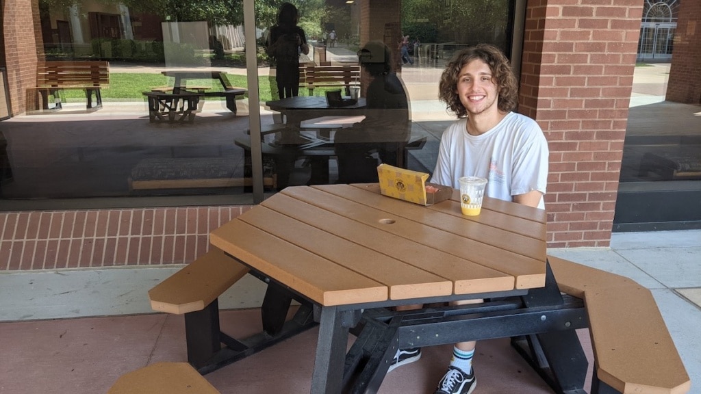 Murray State University student eating at a table outside