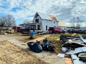 Rusty Blauser of Trigg County tosses a piece of lumber while helping a crew make house repairs on Tuesday, Dec. 14, 2021, in Pembroke. (Photo by Jennifer P. Brown, Hoptown Chronicle)