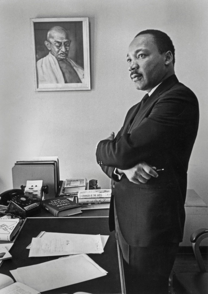 Martin Luther King Jr in front of Gandhi portrait