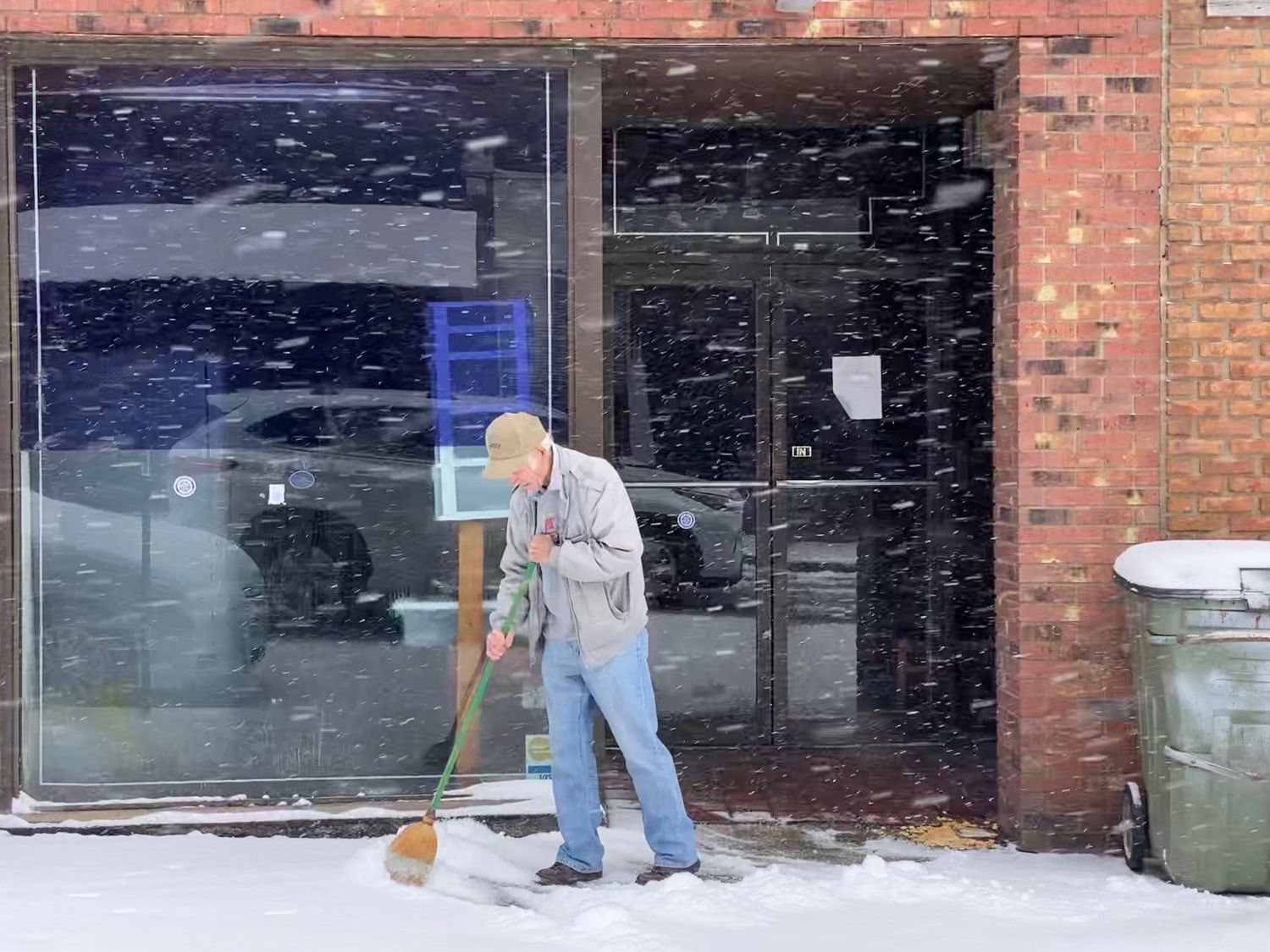 A man sweeps snow in front of Lee's Game Room on South Main Street in Hopkinsville on Thursday, Jan. 6, 2022. (Photo by Jennifer P. Brown)