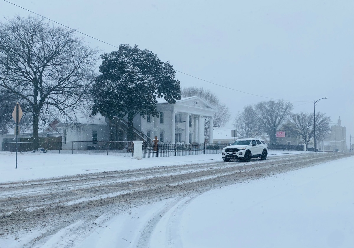 A car drives down Main Street as snow falls in Hopkinsville on Thursday, Jan. 6, 2022. (Photo by Jennifer P. Brown)