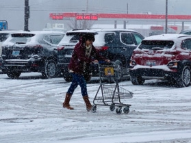 Snow falls on a shopper pushing a cart outside of Kroger in Hopkinsville on Thursday, Jan. 6, 2022. (Photo by Jennifer P. Brown)
