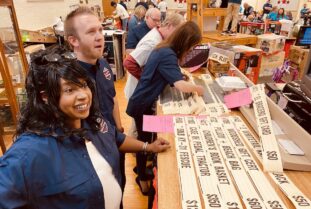Rotarians Amy Rogers and Chase Thomas watch bids being placed on boards at the Rotary Auction on Monday, April 18, 2022 in the Memorial Building. (Photo by Jennifer P. Brown)
