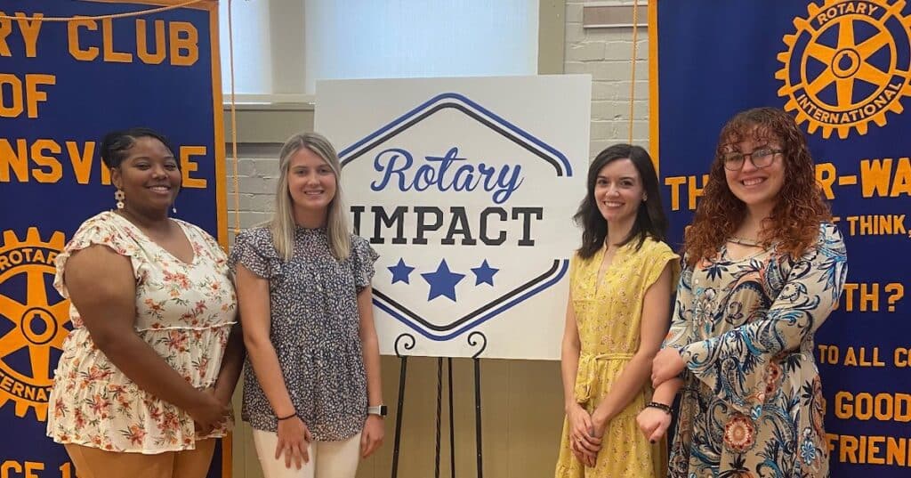 students next to rotary sign