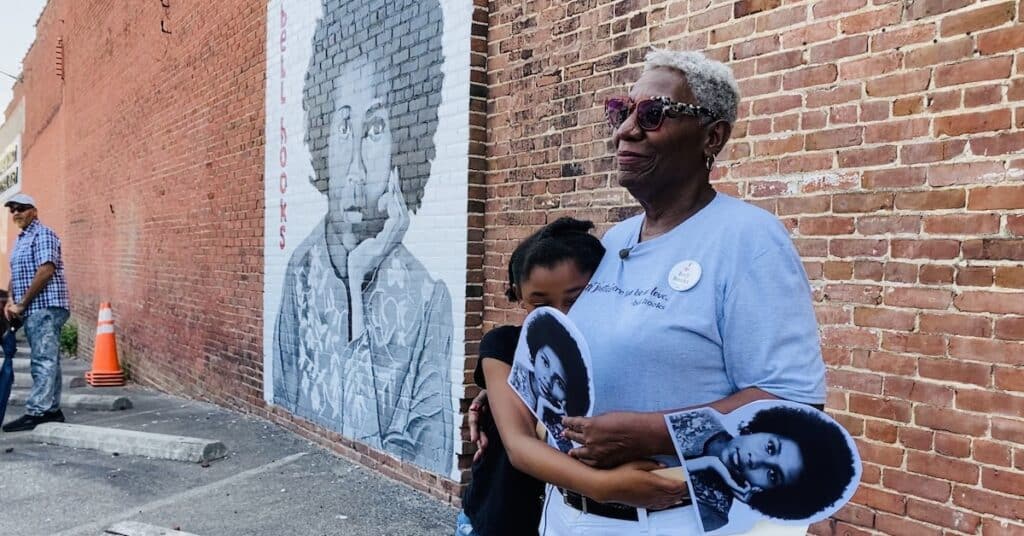 bell hooks sister andyoung family member in front of mural