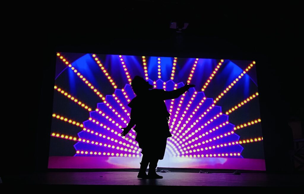 something rotten actor silhouette infront of lights