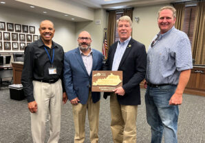 Hopkinsville Mayor Wendell Lynch (far left), Kentucky League of Cities Executive Director and CEO James D. Chaney (second from left) and Christian County Magistrate Jerry Gilliam (far right) present Rep. Walker Thomas with a 2022 “Friend of Kentucky Cities” award. (Kentucky League of Cities photo)