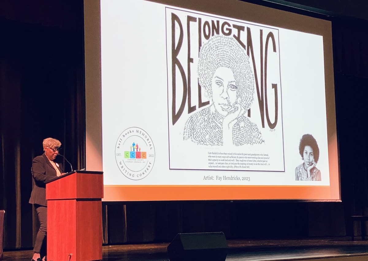 Gwenda Motley reads from her sister bell hooks' book, "Belonging: A Culture of Place," during a ceremony Sunday, March 19, 2023, at the Performing Arts Center at Christian County Middle School, where winners in a writing contest were recognized. (Hoptown Chronicle photo by Jennifer P. Brown)