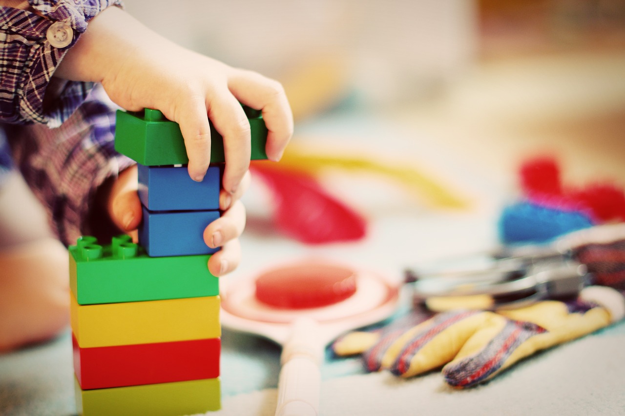 child's hand playing with blocks