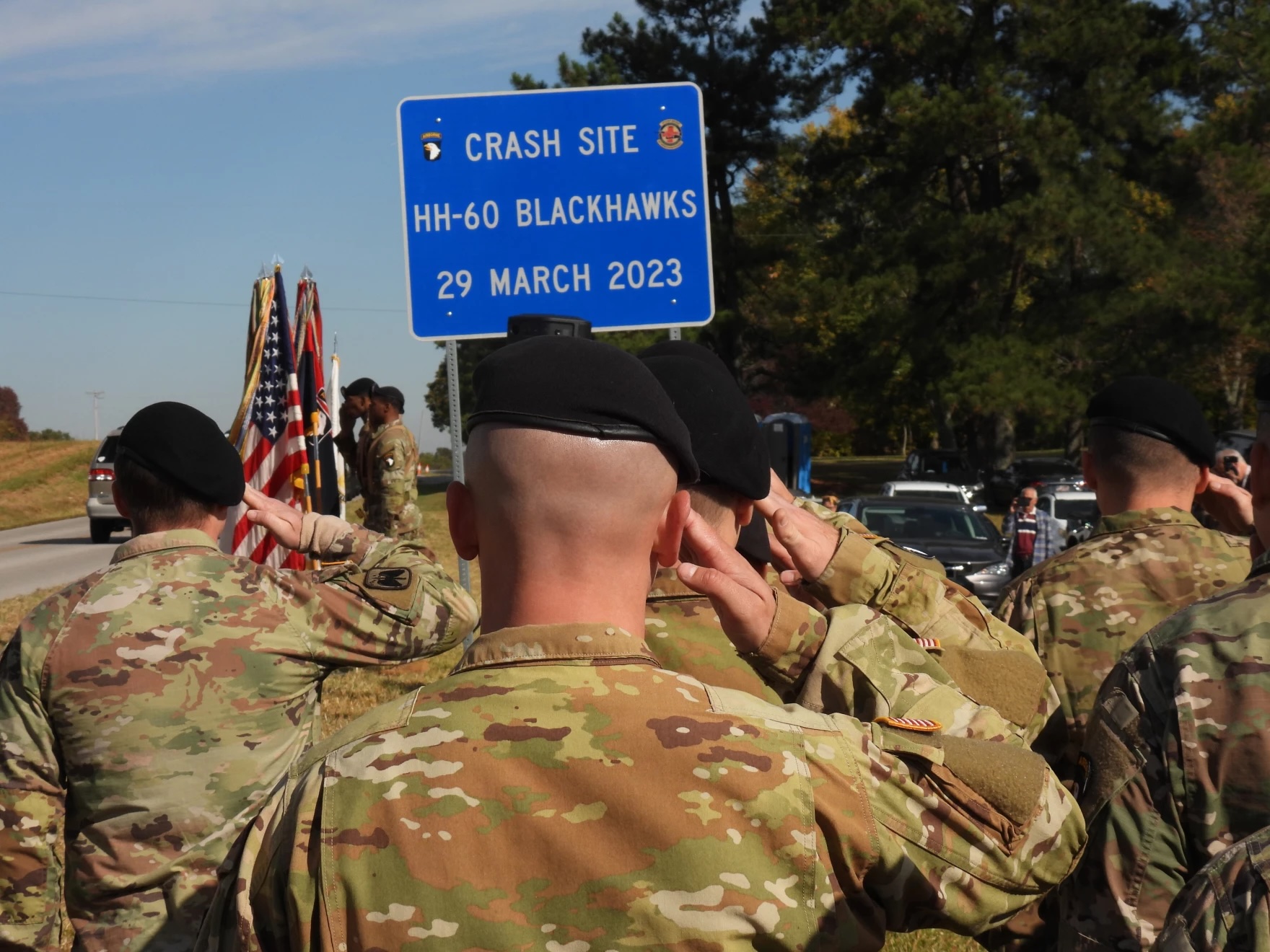 crash site sign with soldiers backs