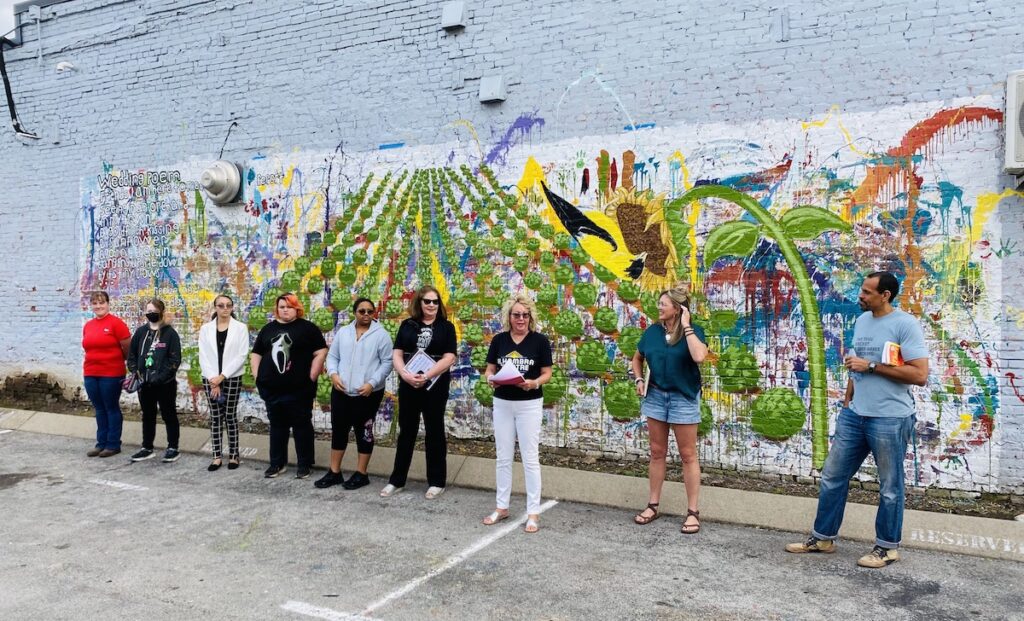 Author Ross Gay (right) joins community members a the 2023 Big Read mural unveiling on the Hopkinsville Brewing Co.'s exterior wall. (Hoptown Chronicle photo by Jennifer P. Brown)