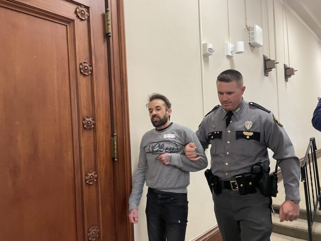 protester being escorted by police officer