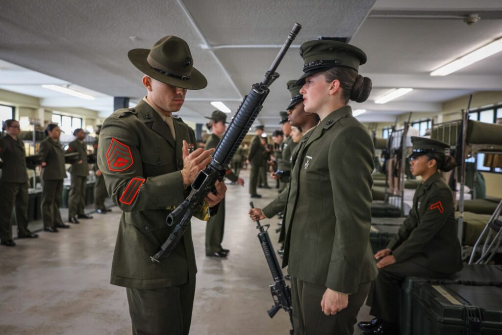 A Marine Corps staff sergeant helps conduct the final inspection of recruit training at Marine Corps Recruit Depot Parris Island, S.C., Jan. 5, 2024. During their last inspection, new Marines are tested on everything they’ve been taught, including uniform standards and discipline. (DOD Photo by Marine Corps Lance Cpl. Ava Alegria)