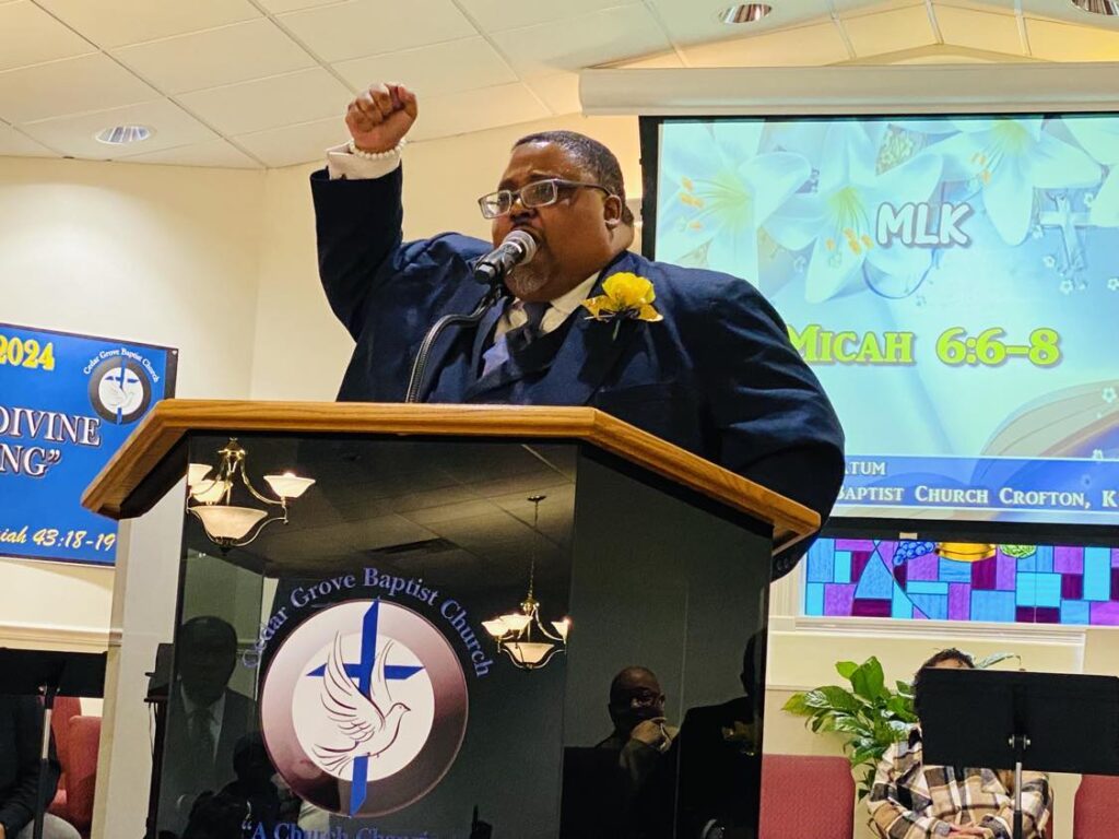 man at podium with fist raised