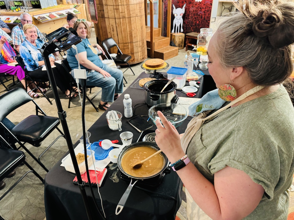 Alissa Keller stirs caramel icing during a Supper Club demonstration on Thursday, June 23, 2024, at the Pennyroyal Area Museum. The icing went on a Kentucky jam cake featured in the 1978 cookbook by Lucile Van Cleve Wallace. (Hoptown Chronicle photo by Jennifer P. Brown)