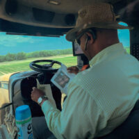 black farmer driving tractor