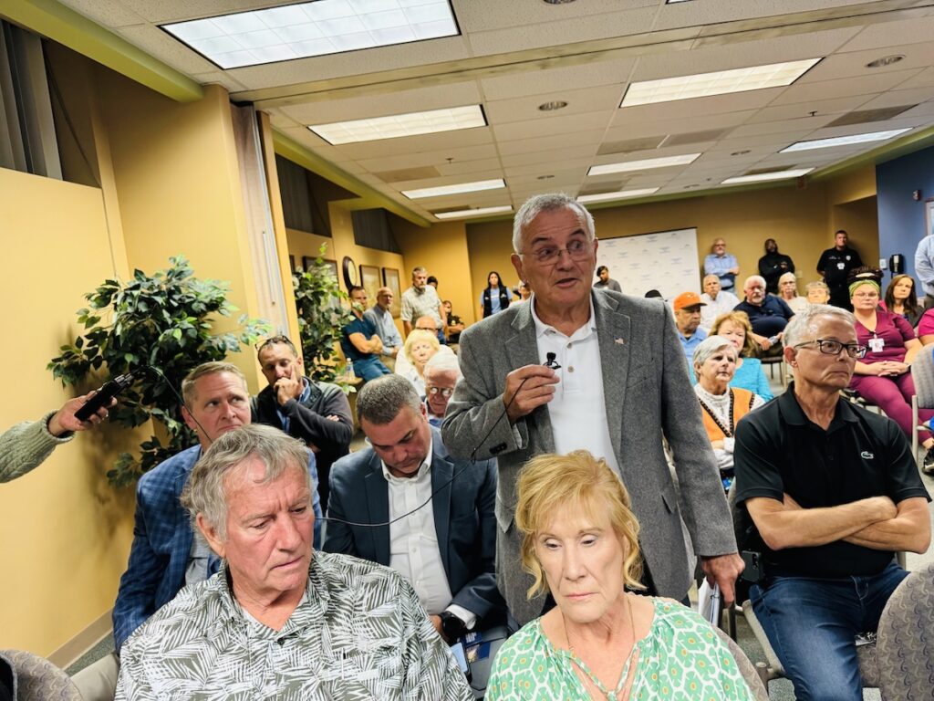 audience member stands at jennie stuart meeting