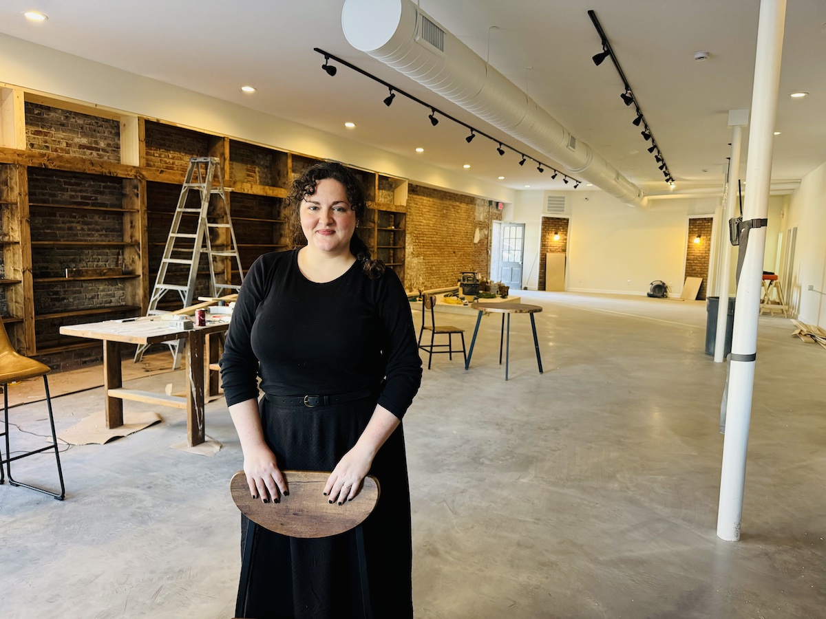 Rachel Sanders stands in the East Ninth Street building where construction continued on Oct. 9, 2024, for her business, The Book & Bottle Shop. (Hoptown Chronicle photo by Jennifer P. Brown)