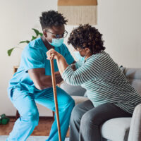 nursing home staff helping resident