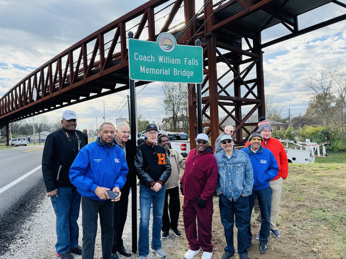 Former basketball players for Attucks and Hopkinsville high schools (from left) Jonathan White, Arnold Lynch, James Victor, Russell Hayes, Orlando Frame, Melvin Woodard, Kenneth Tompkins, Wendell Lynch and Mike Walker. pose during a dedication ceremony on Wednesday, Dec. 4, 2024, to name the Hopkinsville Greenway pedestrian bridge for their coach, the late William Falls. (Hoptown Chronicle photo by Jennifer P. Brown)