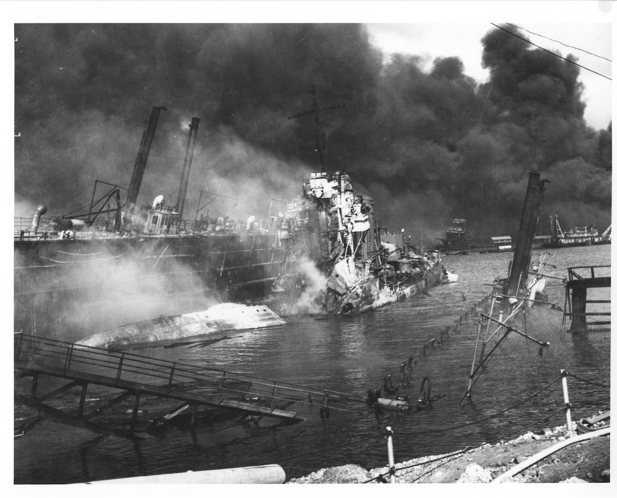 The USS Shaw lies in drydock after being hit by three bombs which exploded her forward magazine in the Dec. 7, 1941, Japanese attack on Pearl Harbor. Part of the drydock at right is under water while while the other side is listing heavily. (Photo from U.S. National Archives)