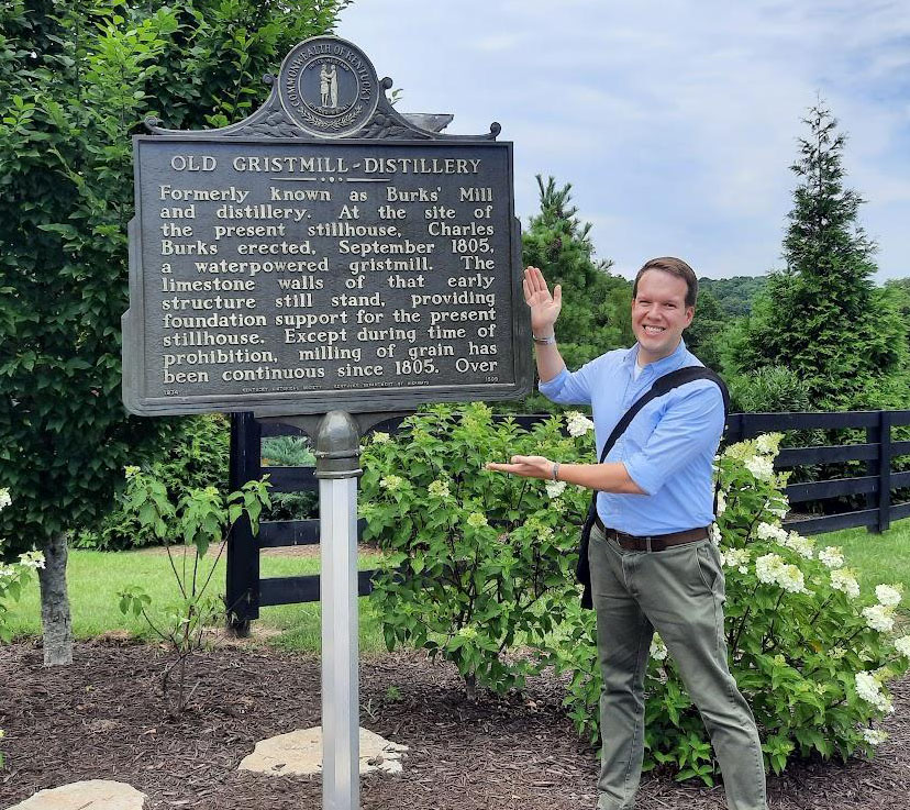 man next to historical marker