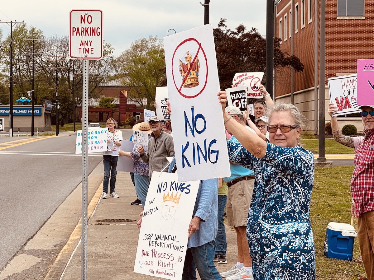 Barb Edwards, of Clarksville, Tennessee, lifts her protest sign for a passing motorist Saturday, April 19, 2025, in downtown Hopkinsville. She joined a couple dozen people who rallied against policies of President Donald Trump. (Hoptown Chronicle photo by Jennifer P. Brown)