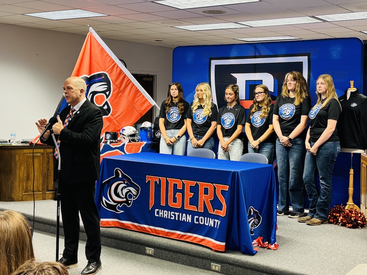 Several high school girls wearing new Christian County High School Tiger mascot shirts joined a news conference with Superintendent Chris Bentzel (at the mic) Thursday, May 15, 2025, at the central office as officials revealed the branding for the school that will open in August 2026. (Hoptown Chronicle photo by Jennifer P. Brown)