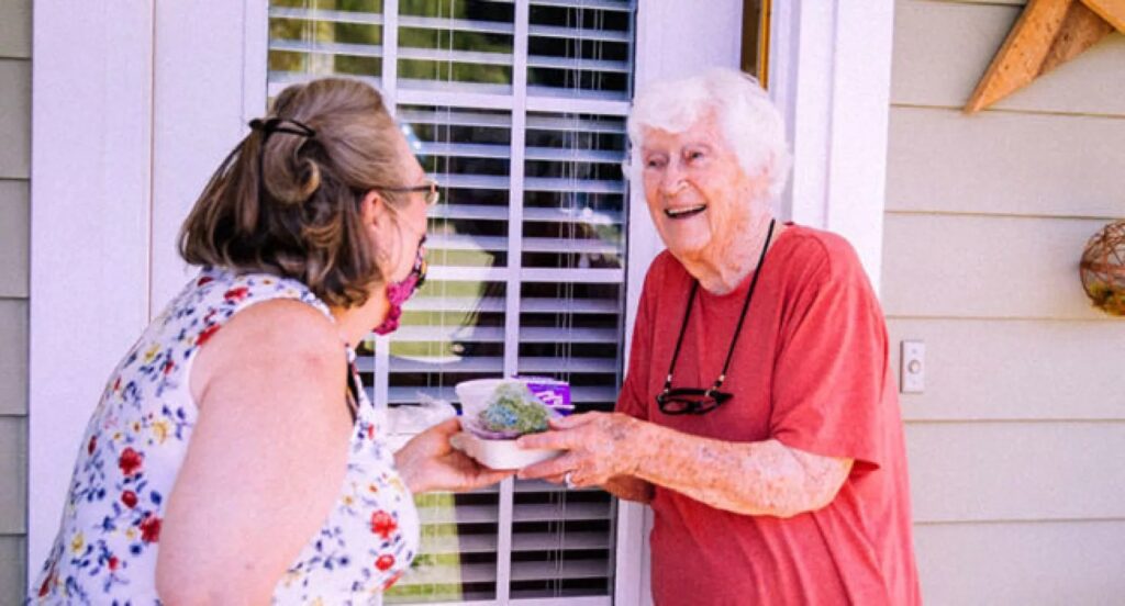senior woman being handed meal
