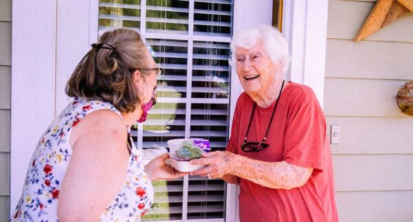 senior woman being handed meal