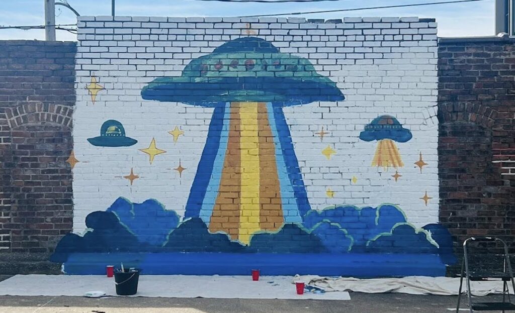 ufo mural on brick wall