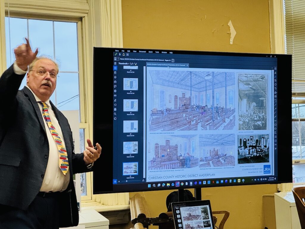man standing next to computer with renderings of Christian County Courthouse