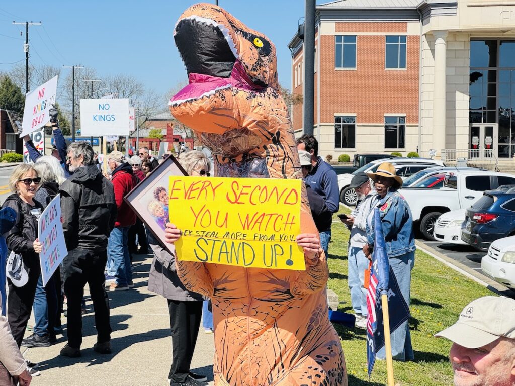 protester wearing inflatable dinosaur