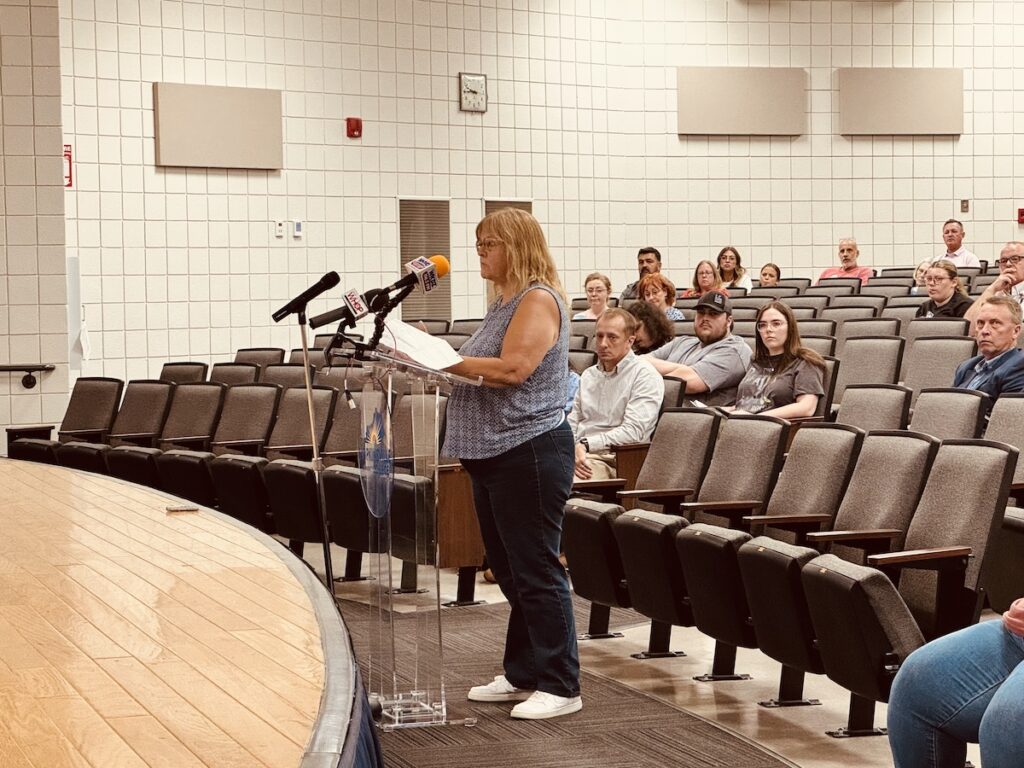 woman at podium during public hearing