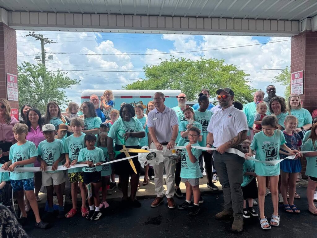 children and adults cut ribbon