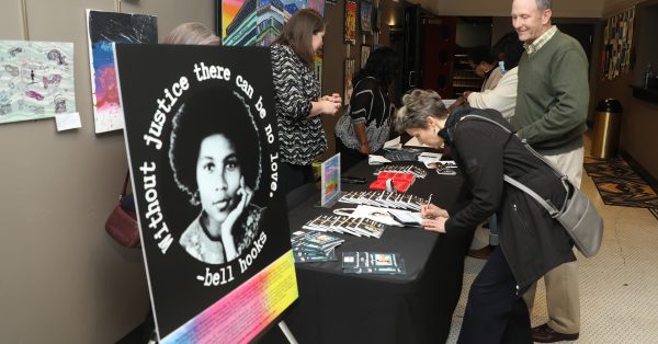 Hopkinsville residents Rosemary and Lewis Bradley purchase bell hooks items during a celebration of the Hopkinsville native and iconic feminist author on Saturday, April 2, 2022, at the Alhambra Theatre in Hopkinsville. (Tony Kirves | Special to Hoptown Chronicle)