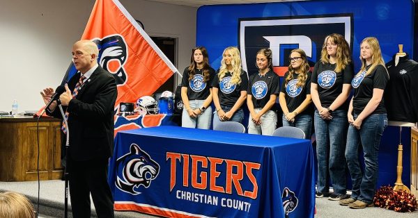 Several high school girls wearing new Christian County High School Tiger mascot shirts joined a news conference with Superintendent Chris Bentzel (at the mic) Thursday, May 15, 2025, at the central office as officials revealed the branding for the school that will open in August 2026. (Hoptown Chronicle photo by Jennifer P. Brown)