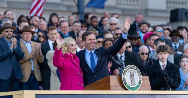 Gov. Andy Beshear and his wife Britainy wave to the crowd Tuesday at the public swearing-in ceremony in Frankfort. (Photo by J. Tyler Franklin)