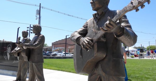 Life-size bronze statues of John Prine and the Everly Brothers — Don and Phil — were dedicated Friday in Central City, where the artists' had deep roots. Prine's parents were both from Muhlenberg County, which he immortalized in his song "Paradise." (WKMS photo by Derek Operle)