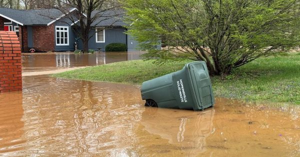 Herbie Curbie trash container floats in floodwater at the end of West Riverwood Drive on Friday, April 4, 2025. (Hoptown Chronicle photo by Jennifer P. Brown)