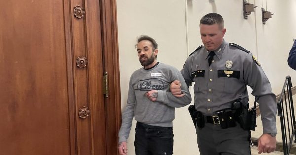 A Kentucky State Police officer removed a protester who was part of a group shouting from the gallery March 29, 2023, as the House debated overriding Gov. Andy Beshear’s veto of anti-trans Senate Bill 150. (Kentucky Lantern photo by Mariah Kendell)