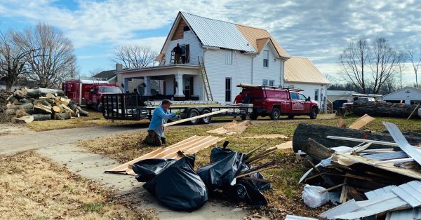 Rusty Blauser of Trigg County tosses a piece of lumber while helping a crew make house repairs on Tuesday, Dec. 14, 2021, in Pembroke. (Photo by Jennifer P. Brown, Hoptown Chronicle)