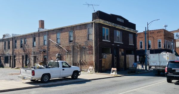 A truck belonging to a salvage contractor is parked Wednesday morning (Aug. 23, 2023) on the Main Street sidewalk next to the Phoenix Building, which is slated for demolition. (Hoptown Chronicle photo by Jennifer P. Brown)