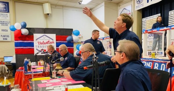 Brandon Killebrew pushes a clip up a wire after retrieving a bid from the line that extends from the audience to the auctioneers at the Hopkinsville Rotary Auction inside the Memorial Building. Killebrew is slated to to chair the 2023 auction. (Photo by Jennifer P. Brown)
