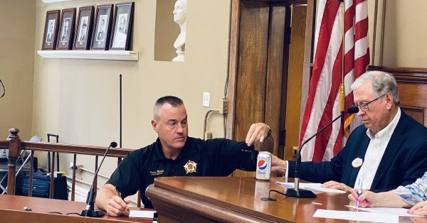 Jason Newby pulls a numbered pill from a coffee mug held by Christian County Clerk Mike Kem during a ballot draw on Thursday, June 9, 2022, at the Christian County Courthouse. Newby is the chief deputy for the Christian County Sheriff's Department and serves on the county's Board of Elections. (Photo by Jennifer P. Brown)