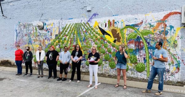 Author Ross Gay (right) joins community members a the 2023 Big Read mural unveiling on the Hopkinsville Brewing Co.'s exterior wall. (Hoptown Chronicle photo by Jennifer P. Brown)