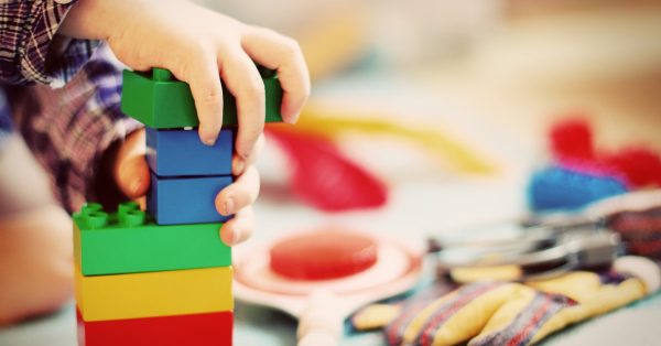 child's hand playing with blocks